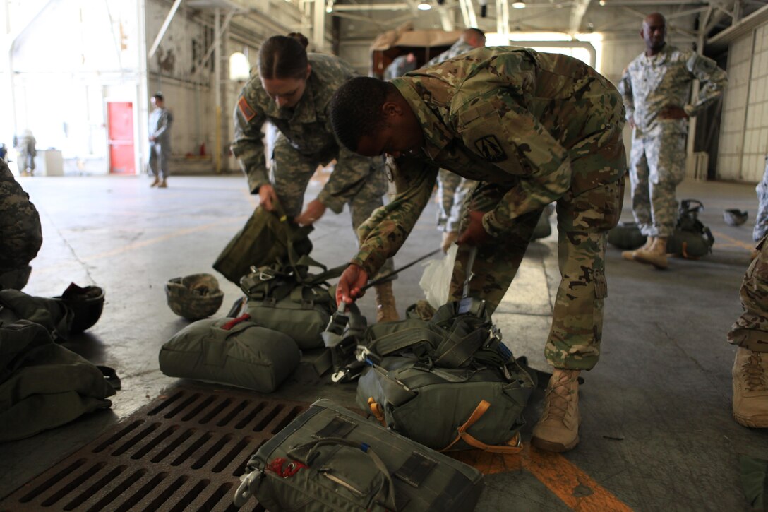 U.S. Army 1st Lt. Terrance Adams, a platoon leader with 982nd Combat Camera Signal Co. prepares his parachute during airborne operations at Fort Bragg, N.C., Oct. 26, 2015. 1st Lt. Adams is a guest jumper with U.S. Army Civil Affairs and Psychological Operations Command, as they conduct airborne operations in order to maintain proficiency and familiarization with the C-27 aircraft. Photo by Sgt. 1st Class Sean A. Foley (Released)