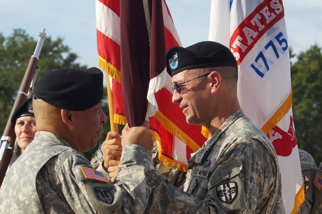 Maj. Gen. Bryan R. Kelly (right) the outgoing commander of the Army Reserve Medical Command, passes the guidon to Maj. Gen. Luis R. Visot, the U.S. Army Reserve Command chief of staff, during the ARMEDCOM change of command ceremony held Sept. 26, 2015 at the C.W. Bill Young Armed Forces Reserve Center in Pinellas Park, Fla. The passing of the guidon from Kelly to Visot symbolized Kelly relinquishing his authority and command responsibility of ARMEDCOM. After 26 years of dedicated service to the U.S. Army Reserve, Kelly is retiring. He plans to spend more time with his family and continue his civilian career as a clinical psychologist near his hometown of East Sandwich, Mass.