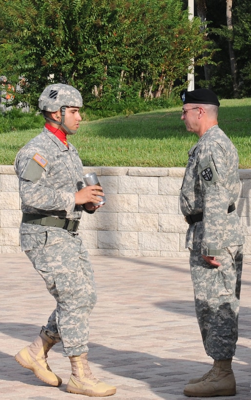 1st Lt. Mario Mendez, the officer in charge of the Salute Battery, 1st Battalion, 10th Field Artillery Regiment, 3rd Infantry Division, presents the last shell fired to Maj. Gen. Bryan R. Kelly, the outgoing commanding general of the Army Reserve Medical Command, during a change of command ceremony held Sept. 26, 2015 at the C.W. Bill Young Armed Forces Reserve Center in Pinellas Park, Fla. Kelly is retiring, after 26 years of military service, and plans to spend more time with his family and continue his civilian career as a clinical psychologist near his hometown of East Sandwich, Mass.
