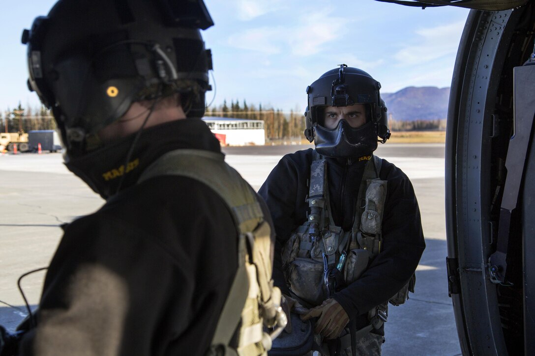Army Staff Sgt. Kevan Katkus, left, and Sgt. Bradley McKenzie prepare their UH-60 Black Hawk helicopter to conduct flight operations on Joint Base Elmendorf-Richardson, Alaska, Oct. 21, 2015. Katkus and McKenzie are crew chiefs assigned to the Alaska Army National Guard's 1st Battalion, 207th Aviation Regiment. U.S. Air Force photo by Alejandro Pena