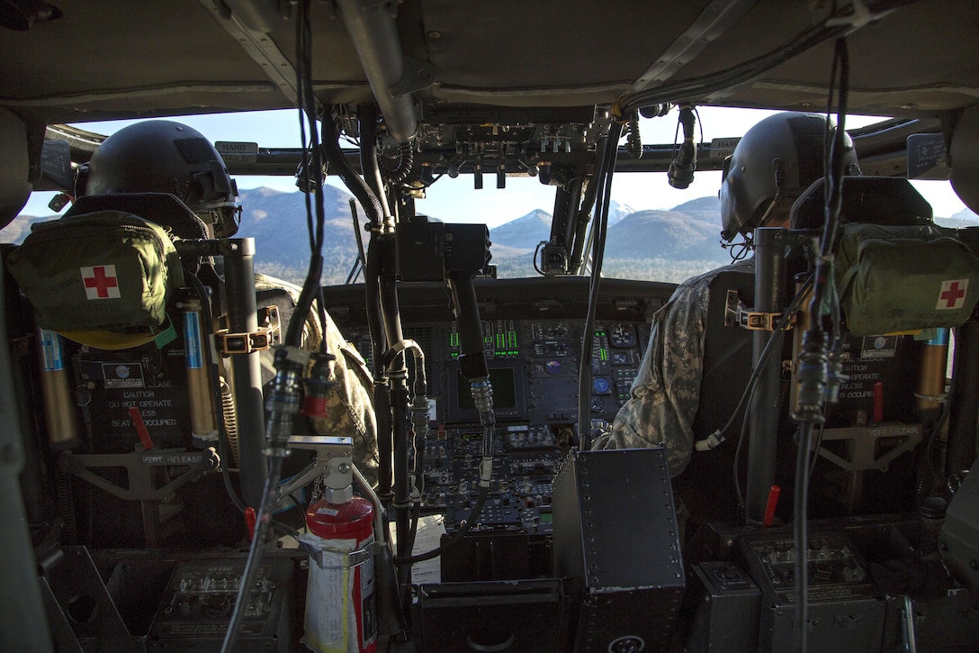 Army Chief Warrant Officer 4 Mark Ward, left, and Capt. Zachary Ward fly a UH-60 Black Hawk helicopter while conducting flight operations over Joint Base Elmendorf-Richardson, Alaska, Oct. 21, 2015. Mark Ward and Zachary Ward are pilots assigned to the Alaska Army National Guard's 1st Battalion, 207th Aviation Regiment. U.S. Air Force photo by Alejandro Pena