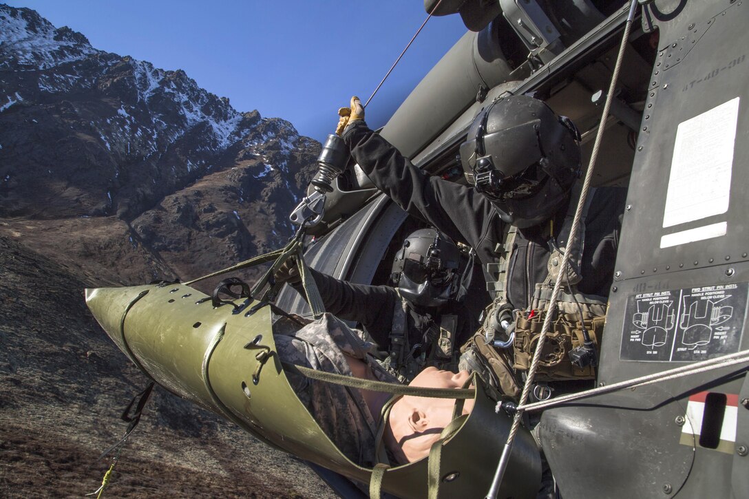 Army Staff Sgt. Bradley McKenzie, right, and Staff Sgt. Kevan Katkus recover a stretcher while conducting rescue hoist training on Joint Base Elmendorf-Richardson, Oct. 21, 2015. McKenzie and Katkus are crew chiefs assigned to the Alaska Army National Guard's 1st Battalion, 207th Aviation Regiment. U.S. Air Force photo by Alejandro Pena