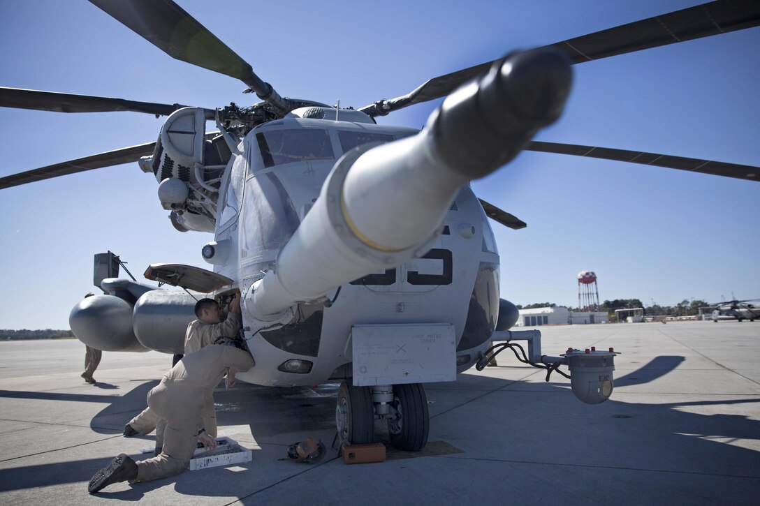 Marines Cpl. Adam Deleon and Lance Cpl. Alexander M. Averhart conduct preflight inspections on a CH-53E Super Stallion helicopter before rappelling training on Marine Corps Air Station New River, N.C., Oct. 20, 2015. Deleon and Averhart are crew chiefs assigned to Marine Heavy Helicopter Squadron 366. U.S. Marine Corps photo by Lance Cpl. Austin A. Lewis