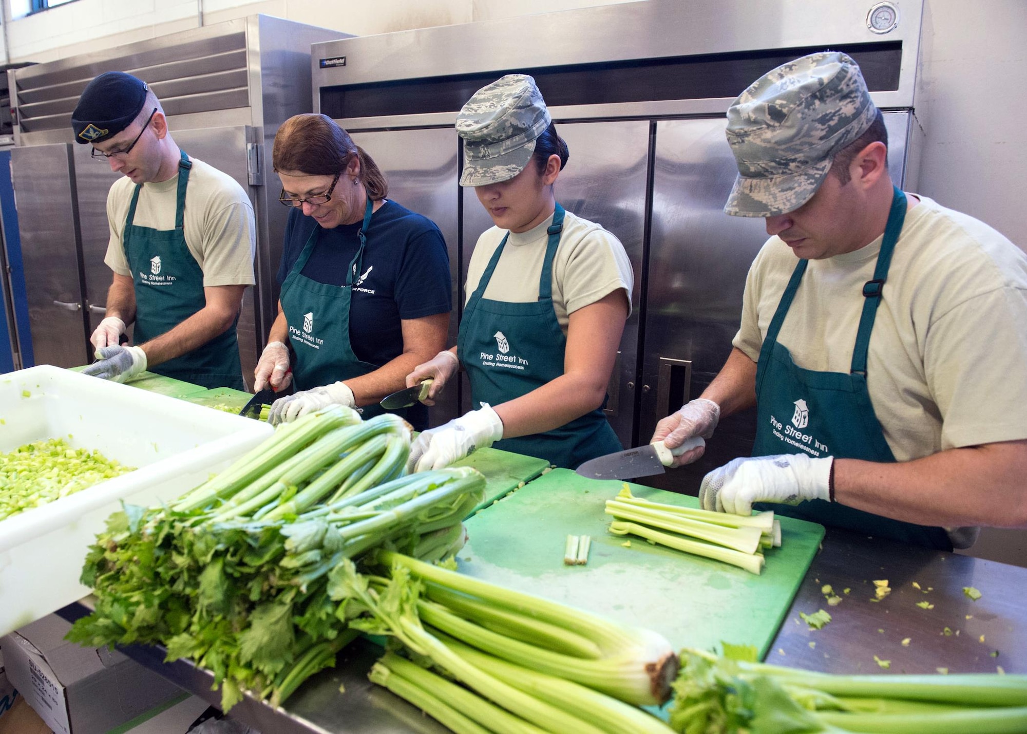 Airmen cut vegetables at the Pine Street Inn while volunteering to prepare meals for more than 1,600 homeless men and women at three Boston area shelters. Pictured from left to right are Staff Sgt. Jamie Ash, a 319th Recruiting Squadron recruiter; Patricia O’Connor, a 319th Recruiting Squadron recruiting flight office administrator; Airman 1st Class Michele Anderson, a 66th Comptroller Squadron Commander's Support Staff administration specialist; and Master Sgt. Nicholas Souza, a 66th Air Base Group first sergeant, who organized the event. (U.S. Air Force photo/Jerry Saslav)