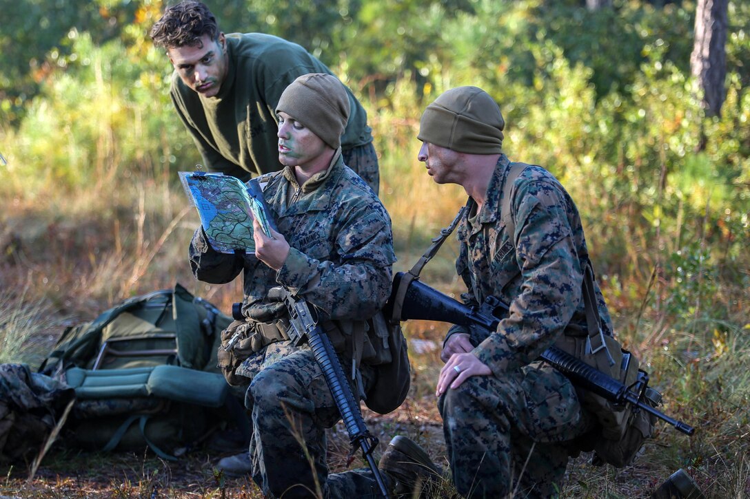 Marines plot their next route during a patrol exercise as part of a scout sniper platoon screening exercise on Marine Corps Base Camp Lejeune, N.C., Oct. 23, 2015. The exercise required candidates to move to an extraction point while evading a simulated enemy. The Marines are with the 2nd Battalion, 8th Marine Regiment. U.S. Marine Corps photo by Cpl. Paul S. Martinez