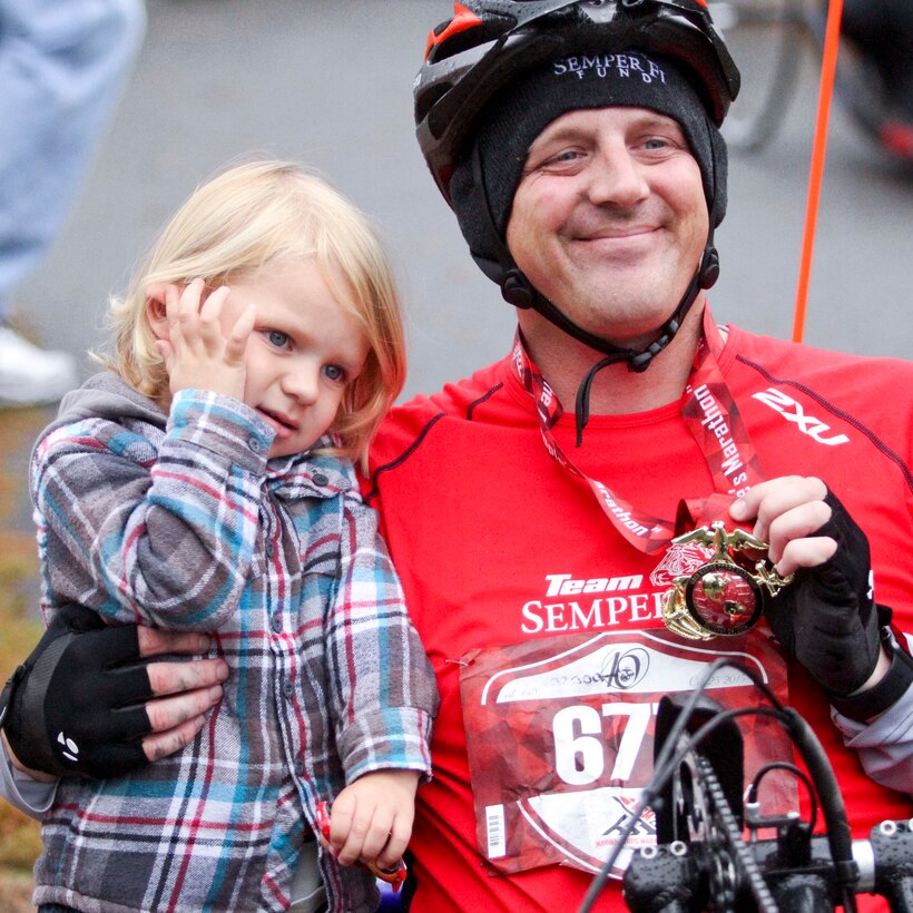 Indiana and his father Staff Sgt. Brandon Dotson celebrate the completion of the Marine Corps Marathon Oct. 25 in Arlington, Va. Dotson is one of many hand cyclists participating in the 40th anniversary marathon.