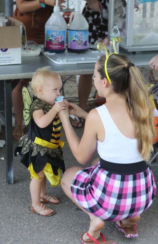 Family members of Marines and Sailors with Marine Aircraft Group (MAG) 16 enjoy snow cones during the MAG-16 Spooktacular aboard Marine Corps Air Station Miramar, Calif., Oct. 24. The Spooktacular had over 100 volunteers from all 12 of MAG-16’s units.