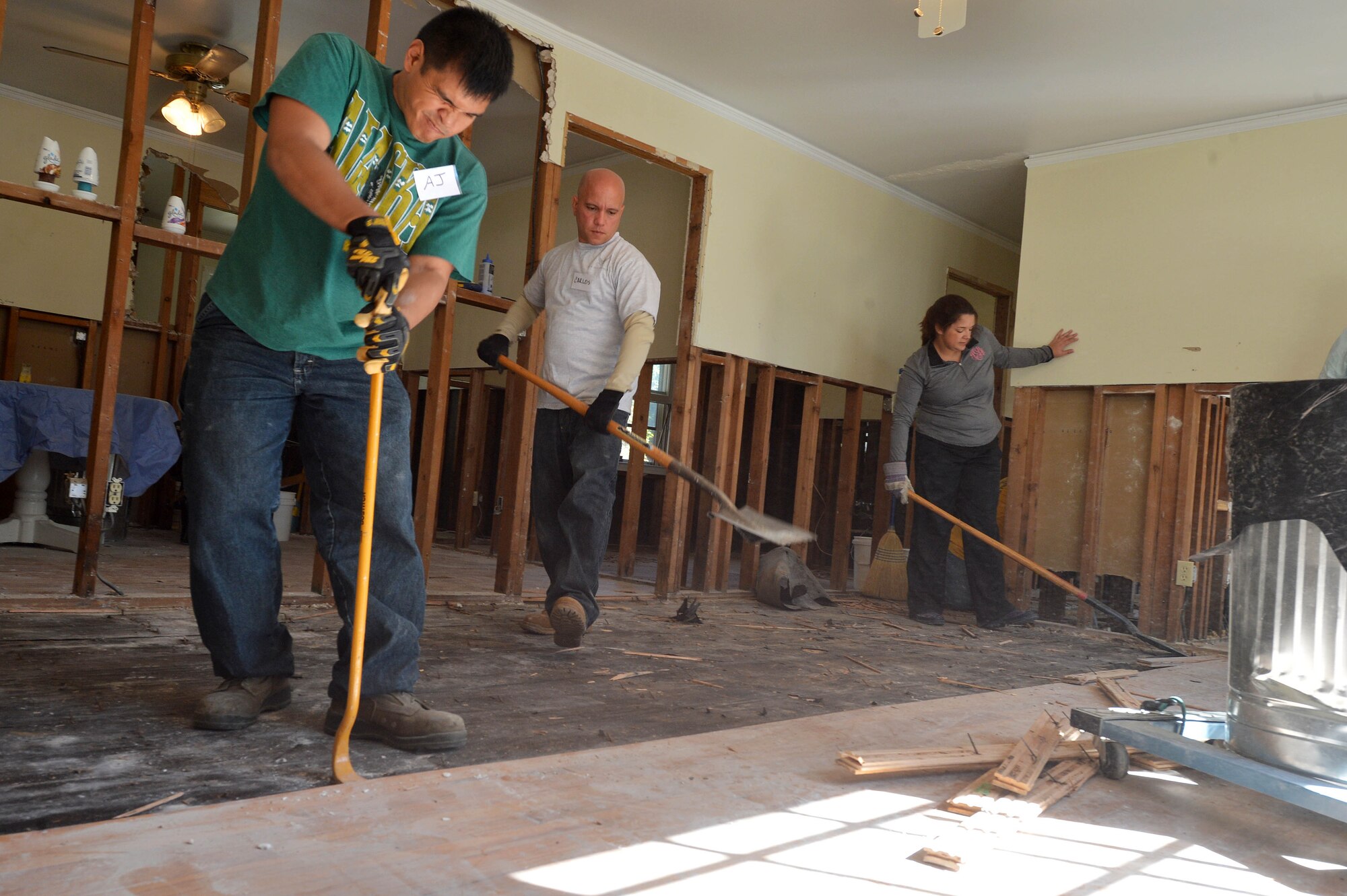Two 20th Civil Engineer Squadron Airmen (left) and a disaster relief volunteer tear up wood floors at a home affected by the flooding in Sumter, S.C., Oct. 19, 2015. Organizations on Shaw Air Force Base, S.C., created multiple groups of more than 85 volunteers to assist in the disaster relief efforts for the Sumter community. (U.S. Air Force photo/Senior Airman Diana M. Cossaboom)