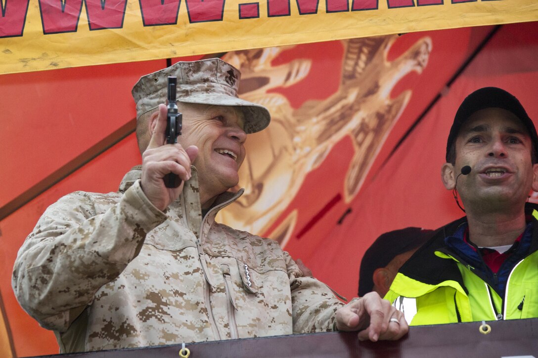 Commandant of the Marine Corps, Gen. Robert B. Neller, prepares the starting pistol to initiate the Marine Corps Marathon at Arlington, Va., Oct. 25, 2015. Over 30,000 runners participated in the 26.2 mile, 40th annual Marine Corps Marathon. (U.S. Marine Corps photo by Sgt. Gabriela Garcia/Released)