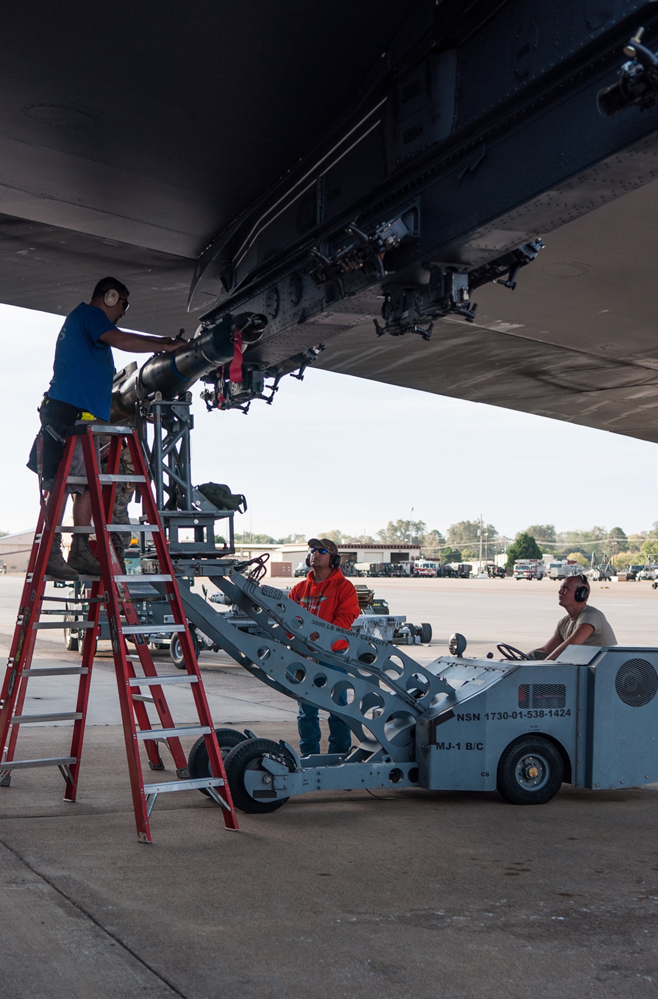 A U.S. Air Force weapons load crew is evaluated on the loading of an inert bomb onto the wing of a B-52 Stratofortress on Barksdale Air Force Base, La., on Oct. 22. The Total Force Integration crew from the Reserve 307th Aircraft Maintenance Squadron and the Active Duty 11th Aircraft Maintenance Unit are required to maintain a certification to be able to handle and load live munitions. (U.S. Air Force photo by Master Sgt. Dachelle Melville/Released)
