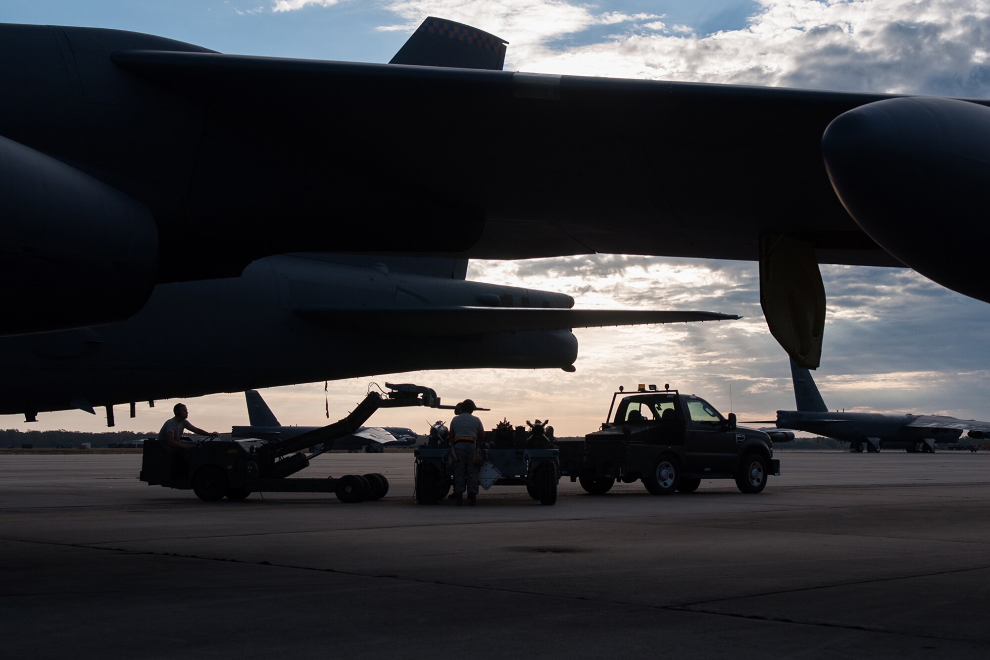 A U.S. Air Force weapons load crew prepares to be evaluated on loading inert bombs onto a B-52 Stratofortress on Barksdale Air Force Base, La., on Oct. 22. The Total Force Integration crew from the Reserve 307th Aircraft Maintenance Squadron and the Active Duty 11th Aircraft Maintenance Unit are required to maintain a certification to be able to handle and load live munitions. (U.S. Air Force photo by Master Sgt. Dachelle Melville/Released)