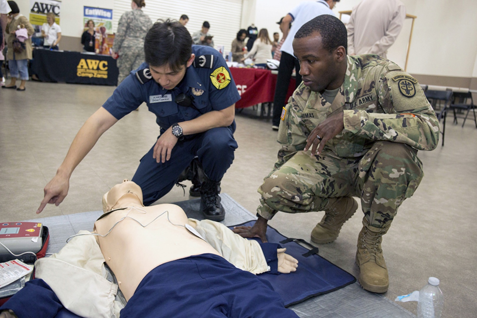 CAMP ZAMA, Japan (Oct. 28, 2015) - Pfc. Sherrad Thomas, assigned to Medical Command, Public Health Command Region-Pacific, learns about CPR and the automated external defibrillator from a Sagamihara City Fire Bureau employee during the fall/winter health and safety fair held Oct. 23 at the Camp Zama Community Activity Center. 