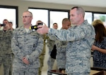 Tech. Sgt. Seth Stockwell, 343rd Training Squadron instructor, left, shows Lt. Gen. Darryl Roberson, commander, Air Education and Training Command, how to properly use a Taser during a tour of the 343rd TRS Oct. 23, 2015, at Joint Base San Antonio-Lackland, Texas. After shooting the device, the commander volunteered to experience a Taser discharge first hand, a requirement of all security forces members who carry the weapon. Roberson visited JBSA-Lackland as part of a tour of all AETC bases to learn about the mission and needs throughout the command. (U.S. Air Force photo by Staff Sgt. Marissa Garner)