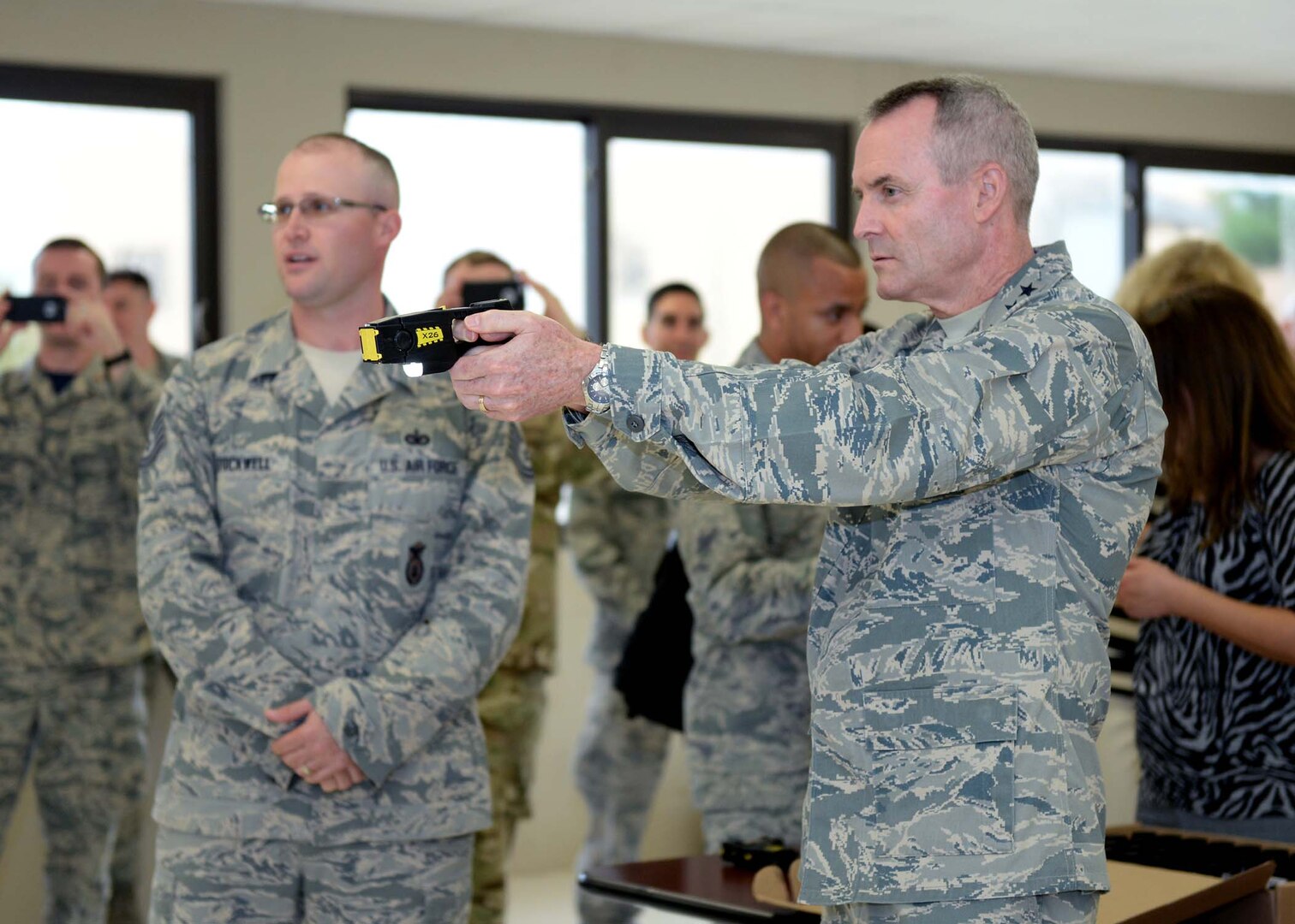 Tech. Sgt. Seth Stockwell, 343rd Training Squadron instructor, left, shows Lt. Gen. Darryl Roberson, commander, Air Education and Training Command, how to properly use a Taser during a tour of the 343rd TRS Oct. 23, 2015, at Joint Base San Antonio-Lackland, Texas. After shooting the device, the commander volunteered to experience a Taser discharge first hand, a requirement of all security forces members who carry the weapon. Roberson visited JBSA-Lackland as part of a tour of all AETC bases to learn about the mission and needs throughout the command. (U.S. Air Force photo by Staff Sgt. Marissa Garner)