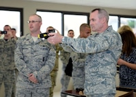 Tech. Sgt. Seth Stockwell, 343rd Training Squadron instructor, left, shows Lt. Gen. Darryl Roberson, commander, Air Education and Training Command, how to properly use a Taser during a tour of the 343rd TRS Oct. 23, 2015, at Joint Base San Antonio-Lackland, Texas. After shooting the device, the commander volunteered to experience a Taser discharge first hand, a requirement of all security forces members who carry the weapon. Roberson visited JBSA-Lackland as part of a tour of all AETC bases to learn about the mission and needs throughout the command. (U.S. Air Force photo by Staff Sgt. Marissa Garner)