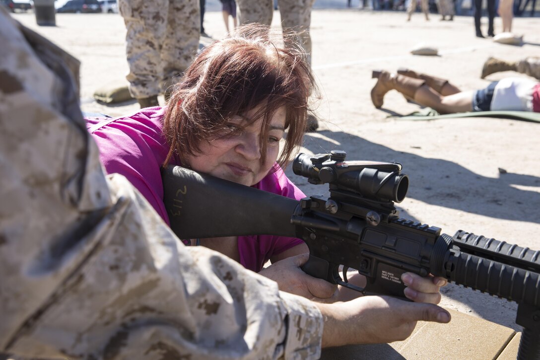 Mirna Rivera, the mother of a Marine with Marine Light Helicopter Attack Training Squadron (HMLAT) 303, holds an M-16 service rifle during the HMLAT-303 Family Day event aboard Marine Corps Base Camp Pendleton, Calif., Oct. 24. Marines and their family members visited one of Camp Pendleton’s ranges to experience firing a service rifle and watch an aerial demonstration. (U.S. Marine Corps photo by Sgt. Lillian Stephens/Released)