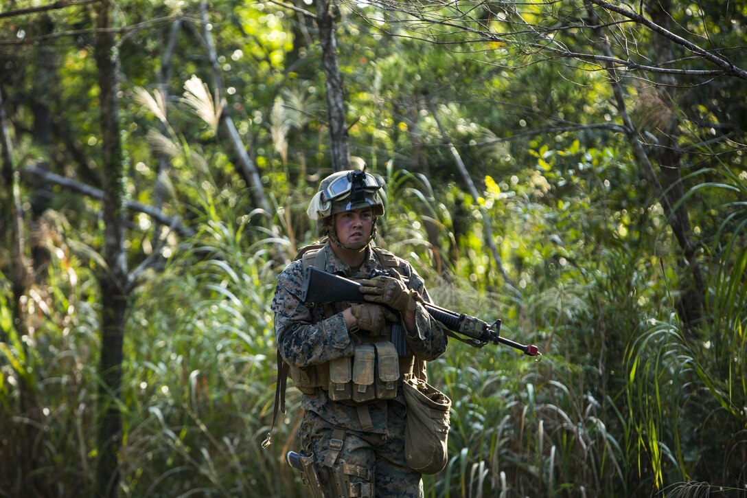 Lance Cpl. Matthew T. Post, a military policeman, conducts a patrol in search of simulated downed aircrew members during Blue Chromite 16 in the Central Training Area, Okinawa, Japan, Oct. 28, 2015. Post, from Orting, Washington, was tasked with tracking down the pilot and two aircrew members and conducted the search throughout a dense wooded area. Blue Chromite is a large-scale amphibious exercise that draws primarily from III Marine Expeditionary Force’s training resources on Okinawa. The location of the training allows participating units to maintain a forward-deployed posture and eliminates the cost of traveling to train. Post is with Bravo Company, 3rd Law Enforcement Battalion, III Marine Expeditionary Force Headquarters Group, III MEF.