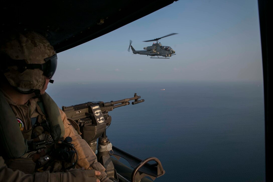 Cpl. Joseph Knolton looks at a Bell AH-1 Super Cobra while returning from recovering a simulated downed aircraft Oct. 28, 2015, during Blue Chromite 16 off the coast of Okinawa, Japan. The mission, which included assets from Marine Air Group 36, also included members of 3rd Law Enforcement Battalion, who recovered personnel with assistance of military working dogs. Blue Chromite is a large-scale amphibious exercise that draws primarily from III Marine Expeditionary Force’s training resources on Okinawa. The location of the training allows participating units to maintain a forward-deployed posture and eliminates the cost of traveling to train. Knolton is from Jackson, Tenn., and a Bell UH-1Y Venom mechanic with MAG 29, HMLA 269, 2nd Marine Aircraft Wing, II Marine Expeditionary Force, currently attached to 1st MAW, III MEF. (U.S. Marine Corps Photo by Cpl. Devon Tindle/Released)