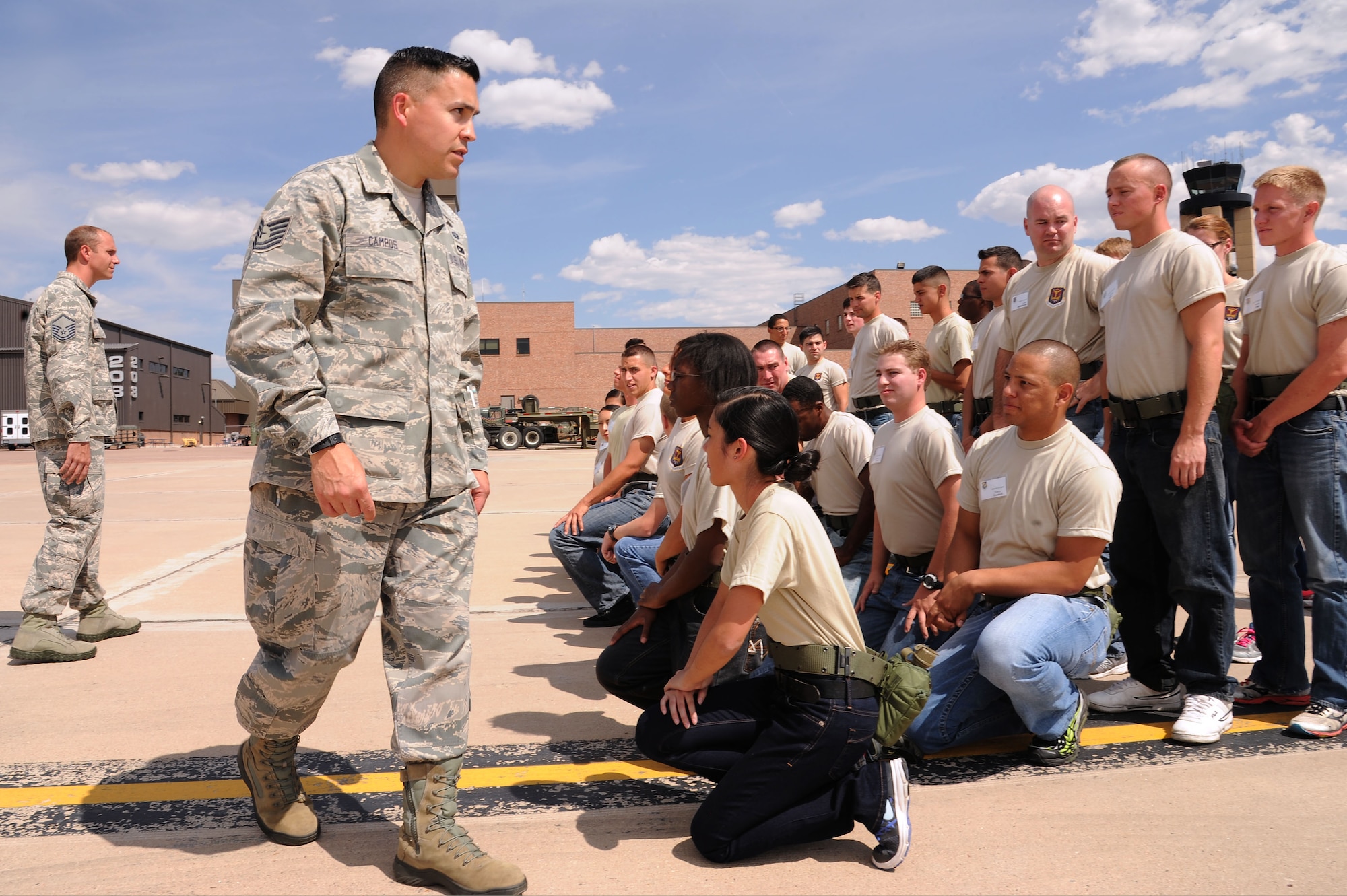 PETERSON AIR FORCE BASE, Colo. – Master Sgt. Jason Broadaway (left) and Tech. Sgt. Darren Campos position trainees with the 302nd Airlift Wing and 310th Space Wing Development and Training Flight into formation for a group photo on Sept. 13, 2015 here. Tech. Sgt. Campos is the 302nd AW D&TF program coordinator and Master Sgt. Broadaway is the 310th SW program coordinator. The focus of D&TF is to prepare trainees for basic training, technical school, and an Air Force career. (U.S. Air Force photo/Senior Airman Amber Sorsek)