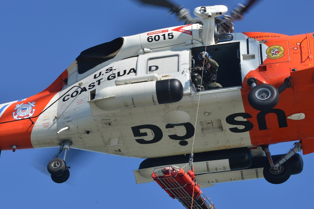 Members of the U.S. Coast Guard and the 73rd Transportation Company U.S. Army tugboat MG Winfield Scott work together in hoisting a mannequin to a helicopter during a casualty evacuation exercise at Fort Eustis, Va., Oct. 21, 2015. The helicopter and vessel crews practiced the hoisting procedures several times to allow the entire crew to get hands-on experience with the procedures. (U.S. Air Force photo by Staff Sgt. Natasha Stannard/Released)