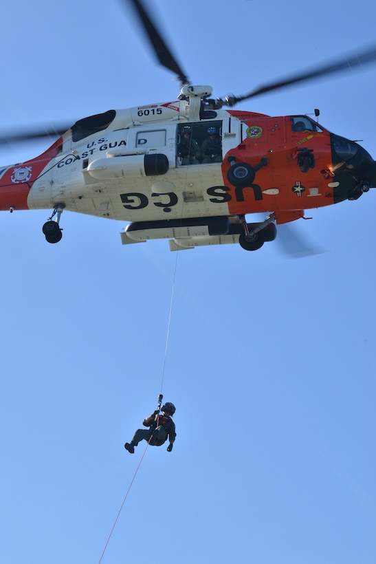 U.S. Coast Guard Petty Officer 3rd Class Kyle McCollum, Air Station Elizabeth City rescue swimmer, repels from a helicopter to the U.S. Army tugboat MG Winfield Scott as part of a joint casualty evacuation exercise at Fort Eustis, Va., Oct. 21, 2015. After landing, McCollum went over Coast Guard patient evacuation procedures and practices with the Army crew, enabling ease of communication and execution (U.S. Air Force photo by Staff Sgt. Natasha Stannard/Released)