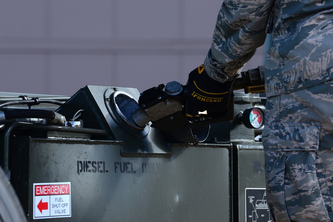 U.S. Air Force Airman 1st Class Joseph Quiros, 633rd Logistics Readiness Squadron air transportation apprentice, fuels a K-Loader at Langley Air Force Base, Va., Oct. 19, 2015. Proper personal protective equipment, such as gloves, is required to be worn by all technicians in the event of splashing or fuel spillage. (U.S. Air Force photo by Senior Airman Kimberly Nagle/Released)     