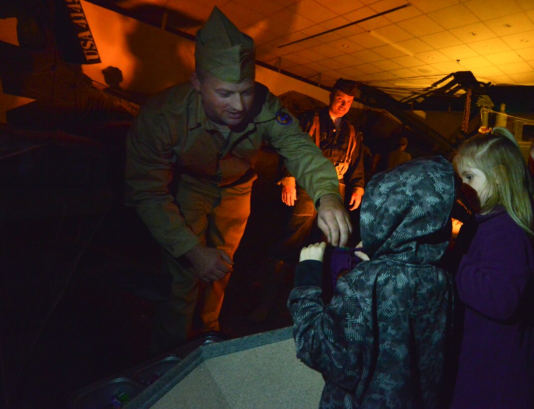 U.S. military role-players hand out candy to children during the 6th annual Night at the Transportation Museum at Fort Eustis, Va., Oct. 26, 2015. Along with receiving candy, children also learned about how life in the military was during time periods ranging from World War I to present day. (U.S. Air Force photo by Staff Sgt. Natasha Stannard/Released)