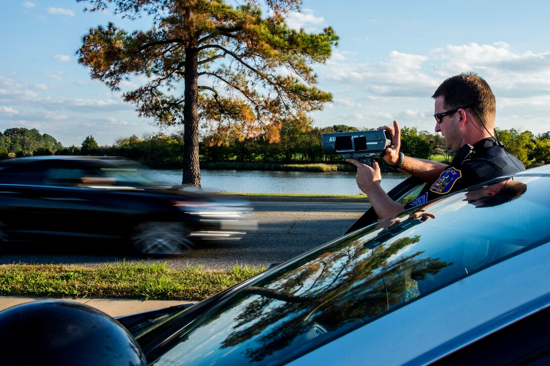 Sergeant Pelham Felder, Hampton Police Division Homeland Security unit supervisor, uses a radar to detect the speed of a passing vehicle at Langley Air Force Base, Va., Oct. 15, 2015. Felder and other members of the Hampton PD conducted training with the 633rd Security Forces Squadron to certify U.S. Air Force Airmen in basic radar operation. (U.S. Air Force photo by Senior Airman Kayla Newman/Released)