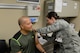 Senior Airman Cassandra Saunders, 56th Medical Operations Squadron aerospace medical technician, administers a flu vaccine to retired Tech. Sgt. Jamie Mayes at Luke Air Force Base, Arizona, Oct. 27, 2015. The medical technicians at the immunizations section administer all routine vaccines and on a walk in basis. They also handle all travel and deployment vaccinations. (U.S. Air Force photo by Senior Airman James Hensley) 