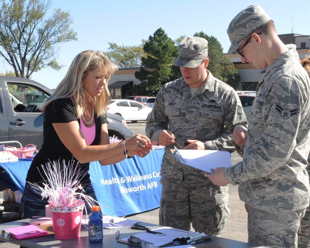 Gerilyn Seal, 28th Medical Operations Squadron health promotion manager, registers Airmen from the 28th Maintenance Squadron during the Walk for Your Cause awareness event at Ellsworth Air Force Base, S.D., Oct. 14, 2015. The walk was an opportunity for Airmen and families to stay active while supporting a variety of causes. (U.S. Air Force photo by Airman 1st Class Denise M. Nevins/Released)