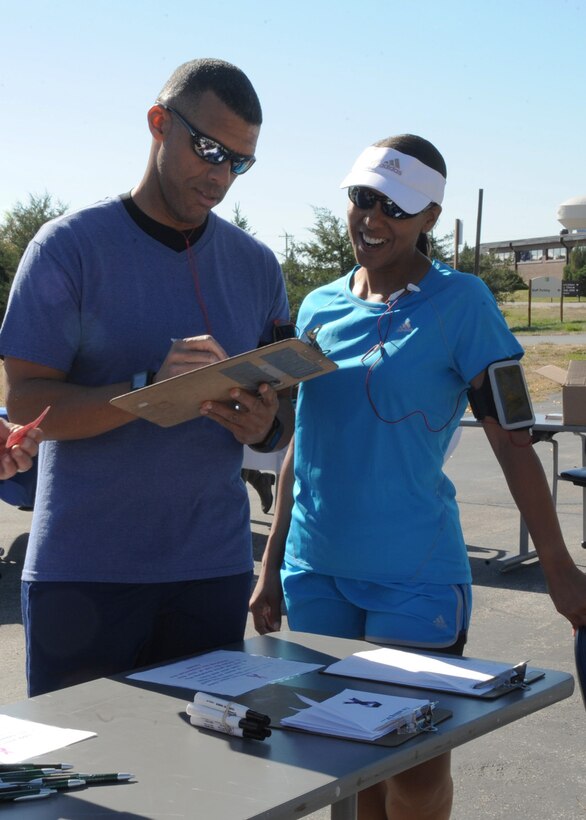 Chief Master Sgt. Sonia Lee, 28th Bomb Wing command chief, and her spouse Kendall Lee, sign up to take part in the Walk for Your Cause awareness event at Ellsworth Air Force Base, S.D., Oct. 14, 2015. Participants walked to support multiple causes, including breast cancer and domestic violence awareness. (U.S. Air Force photo by Airman 1st Class Denise M. Nevins/Released)