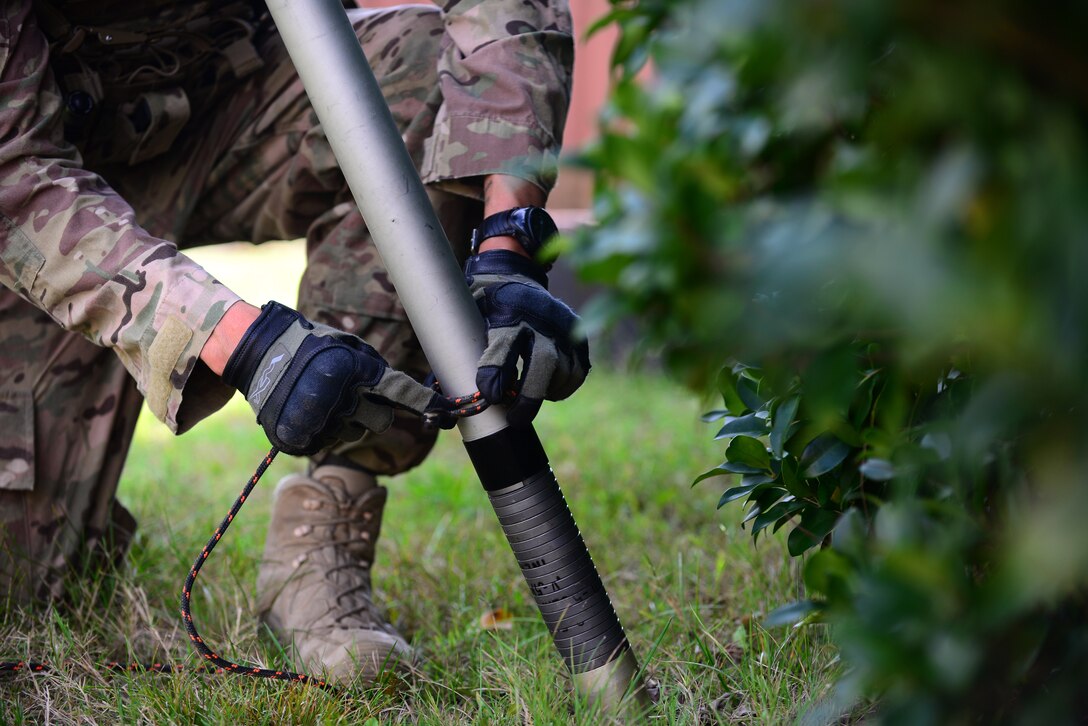 U.S. Air Force Tech. Sgt. Charles Shewmaker, 633rd Civil Engineer Squadron Explosive Ordnance Disposal team lead, ties a rope around a simulated explosive device at Langley Air Force Base, Va., Oct. 14, 2015. As an EOD technician, Shewmaker handles live explosives to train for deployed operations. (U.S. Air Force photo by Senior Airman Kimberly Nagle/Released)  