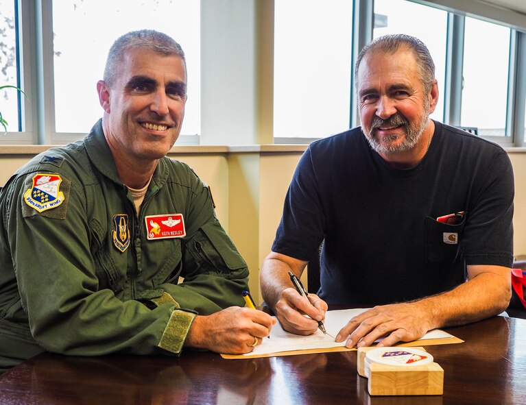 Col. Keith Wesley, 934th Airlift Wing commander, and Mr. Bill Pool, local American Federation of Government Employees president, sign the new collective bargaining agreement between the 934th Airlift Wing and the AFGE union. The new agreement will run for five years. (Air Force Photo by Paul Zadach/Released).