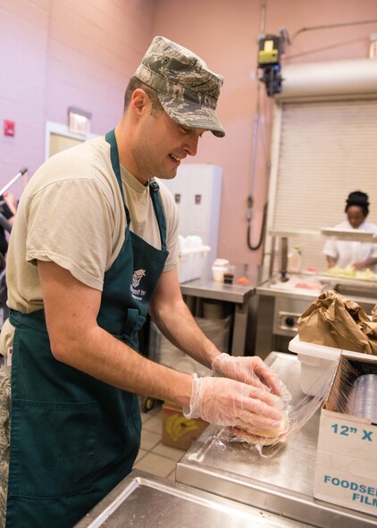 BOSTON -- Tech. Sgt. Jeremy Walter, 66th Air Base Group education and training NCO in charge, wraps a sandwich for a bag lunch while volunteering at the Pine Street Inn Oct.26. Walter worked alongside Pine Street staff members to make sandwiches as part of the shelter’s street outreach program. Each day workers leave the Pine Street Inn’s headquarters on foot to Boston-area neighborhoods to feed those who don’t seek shelter. (U.S. Air Force photo by Jerry Saslav)
