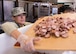 BOSTON -- Staff Sgt. Kelly Portillo, 66th Forces Support Squadron force management apprentice, transfers a cutting board full of sliced sausages destined for Jambalaya while volunteering at the Pine Street Inn Oct.26. Twelve Hanscom Airmen volunteered at the Pine Street Inn to prepare meals for more than 1,600 homeless men and women at three Boston area shelters.  (U.S. Air Force photo by Jerry Saslav)