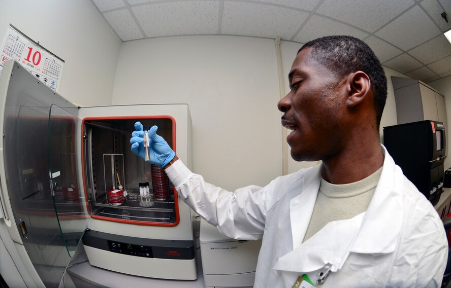 Staff Sgt. Gaetan President, 51st Medical Support Squadron laboratory technician and NCO in charge of hematology, explains the process of incubating a blood culture in a controlled environment in the laboratory at Osan Air Base, Republic of Korea, Oct. 22, 2015. The heated, controlled environment allows bacteria in the culture to react and grow more quickly, which can lead to a faster diagnosis. (U.S. Air Force photo/Tech. Sgt. Travis Edwards)