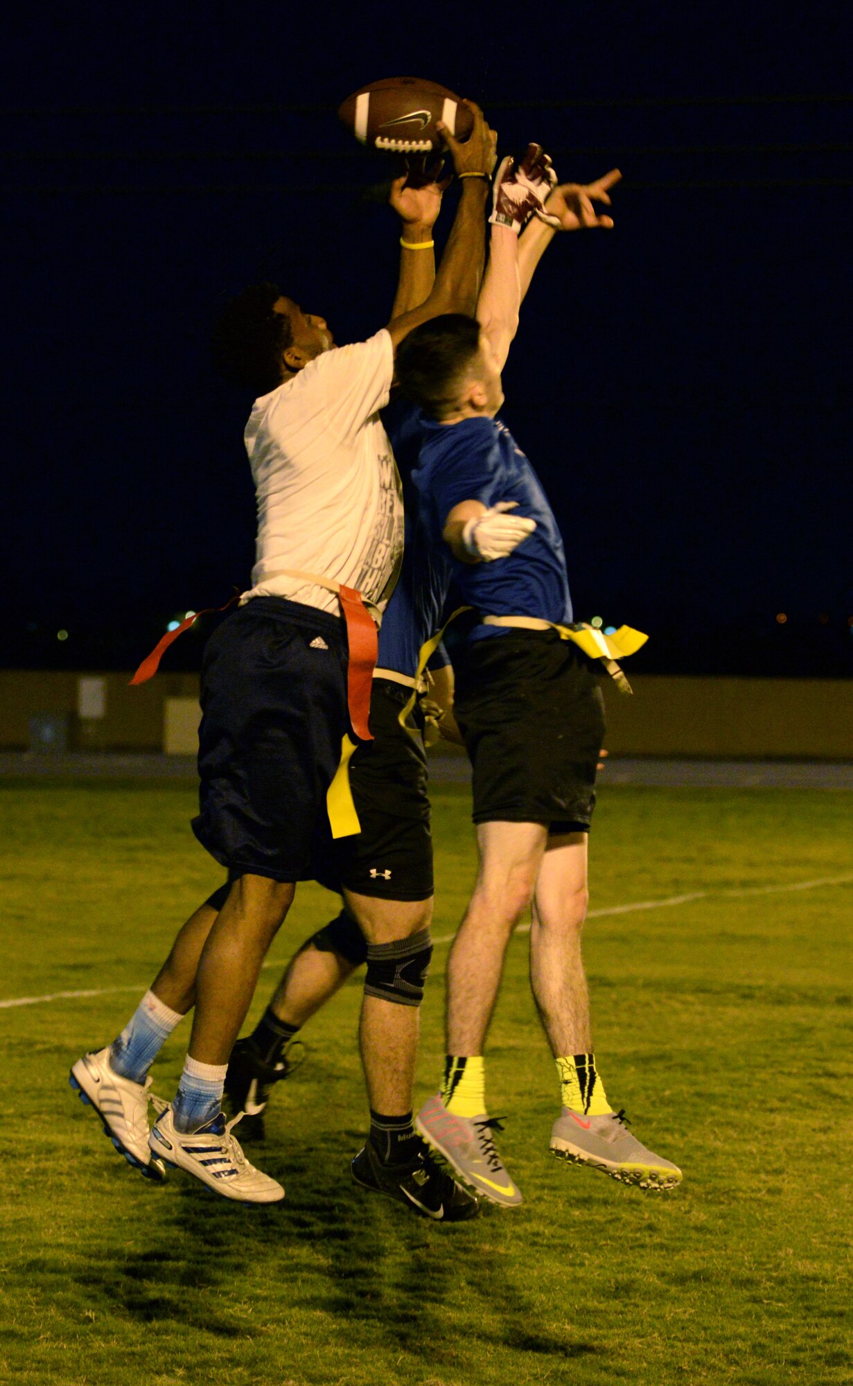 Chris Hamilton, Army and Air Force Exchange Service wide receiver, catches a pass over two defenders, Oct. 26, 2015, at Luke Air Force Base. The AAFES team is a finalist in the championship bracket of the Luke flag football season. (U.S. Air Force photo by Airman 1st Class Ridge Shan)