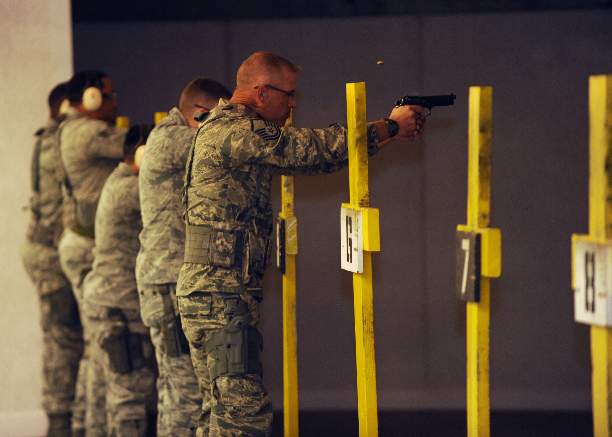 Airmen from the 28th Security Forces Squadron fire the M9 pistol during training at Ellsworth Air Force Base, S.D., Oct. 13, 2015. Prior to firing, personnel receive instruction on safety and weapon control using multiple weapon systems. (U.S. Air Force photo by Airman Sadie Colbert/Released)