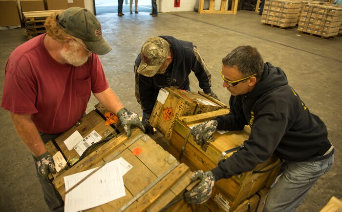 (From left to right) Thomas George, Naval Munitions Command Atlantic Unit Charleston material handling inspector and Naval Munitions Command Atlantic Unit Charleston work leaders, Bryan Shaw and Mark Lamoureux, complete a pallet of equipment on Oct. 27, 2015, at Joint Base Charleston – Naval Weapons Station. The pallet is one of several that will be included in a much larger storage container to be loaded on the United States Naval Ship Red Cloud.