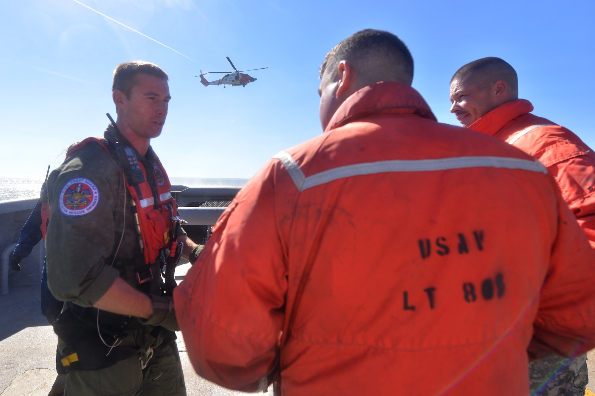U.S. Coast Guard Petty Officer 3rd Class Kyle McCollum, Air Station Elizabeth City rescue swimmer, debriefs 73rd Transportation Company U.S. Army tugboat MG Winfield Scott members after completing a joint casualty evacuation exercise at Fort Eustis, Va., Oct. 21, 2015. The exercise allowed for the Army and Coast Guard to exchange communication practices and rescue procedures for familiarity in real-world emergencies. (U.S. Air Force photo by Staff Sgt. Natasha Stannard/Released)