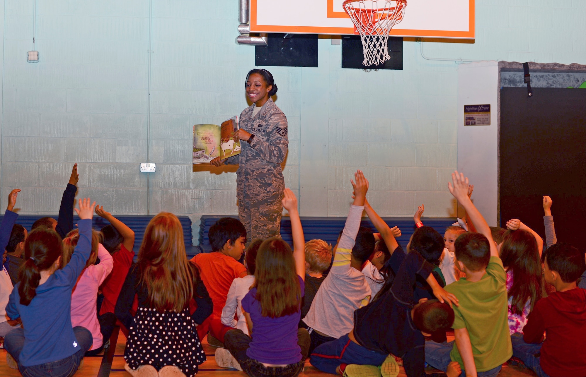 Staff Sgt. Candice Oliver, 100th Force Support Squadron customer support supervisor, reads to children during a worldwide event known as Read Across the Globe, at Royal Air Force Lakenheath Elementary School, England, Oct. 20, 2015. The event was organized to promote literacy amongst school-aged children, with a goal to read to 238,000 children over a 24-hour period in order to qualify for a spot in the Guinness Book of World Records. (U.S. Air Force photo by Senior Airman Erin O’Shea/Released)