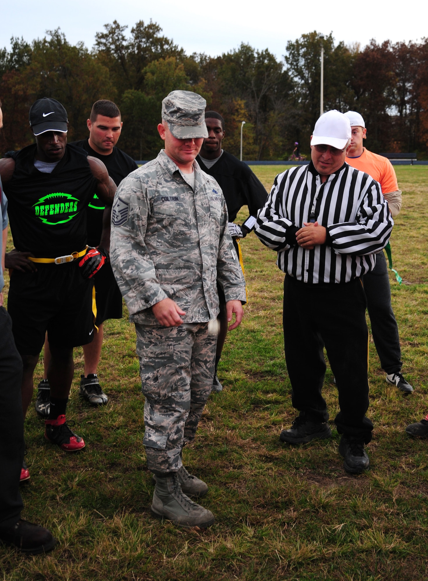 Master Sgt. Matthew Coltrin (middle), 509th Security Forces Squadron (SFS) first sergeant, performs a coin toss before the intramural flag-football championship game at Whiteman Air Force Base, Mo., Oct. 26, 2015. Out of 11 teams, the 509th SFS and 509th Operations Support Squadron played in the final championship game. (U.S. Air Force photo by Senior Airman Joel Pfiester/Released)