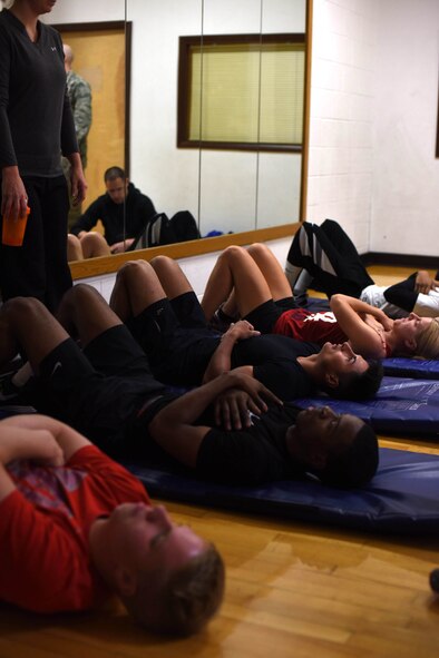 Participants of the Malmstrom Air Force Base physical training competition prepare to complete thesit up portion of the event at the Malmstrom Fitness Center Oct. 27, 2015. Competitors were scored based on completed number of pushups, situps and a mile and a half run. (U.S. Air Force photo/Airman Collin Schmidt) 