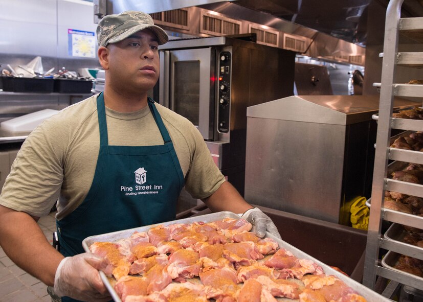 BOSTON -- Master Sgt. Ivan Lucero, 319th Recruiting Squadron flight chief, carries a tray of seasoned chicken breasts during a volunteer effort at the Pine Street Inn Oct.26. Lucero and others from Hanscom volunteered to prepare meals for more than 1,600 homeless men and women in Boston. (U.S. Air Force photo by Jerry Saslav)