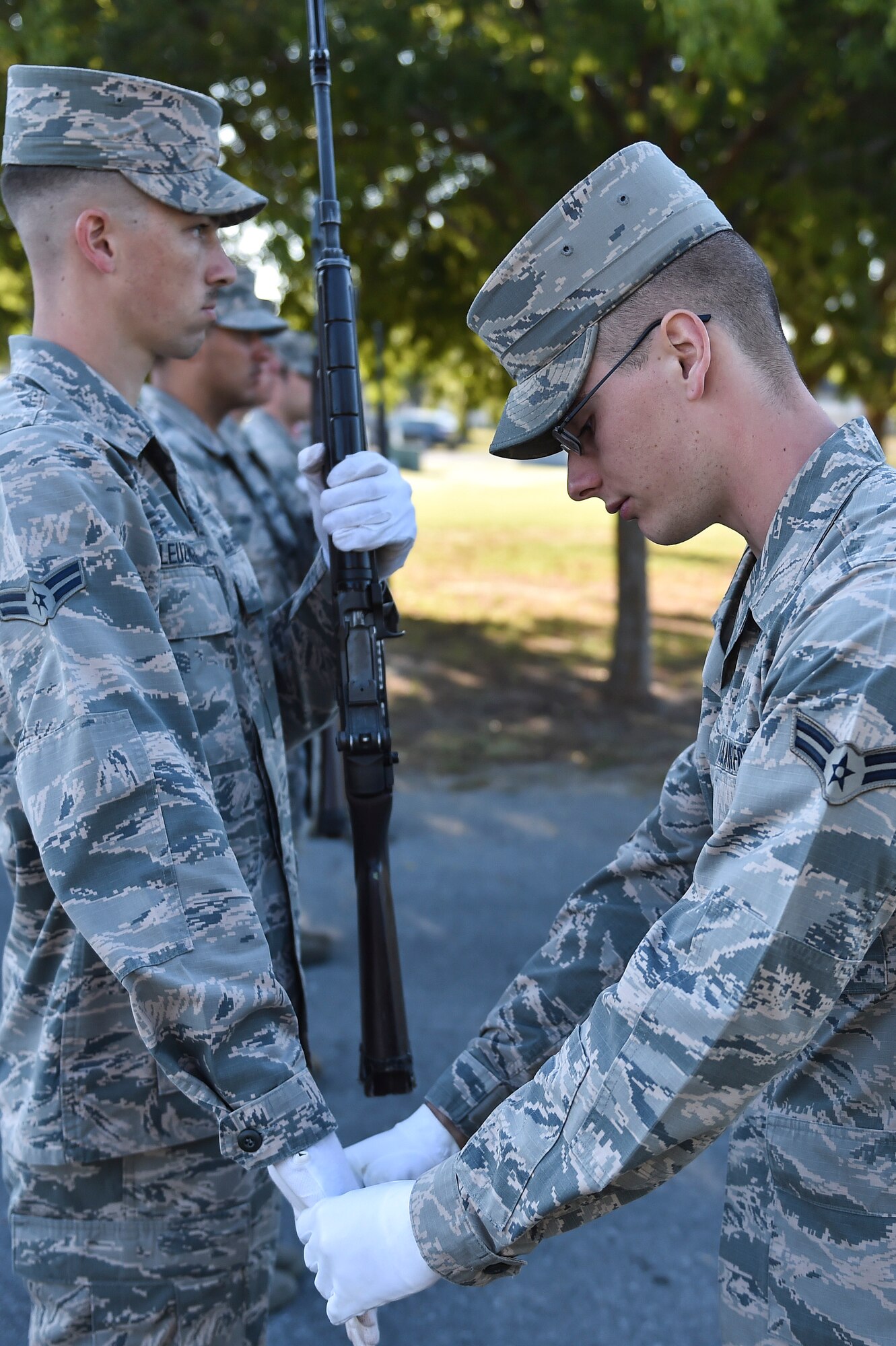 Airman 1st Class Devin James, U.S. Air Force Honor Guard mobile training team instructor, adjusts the hand of A1C Dereck Leuzinger, Eglin Air Force Base Honor Guard member, during training at Hurlburt Field, Fla., Oct. 16. The mobile training team traveled from Bolling AFB, Washington, D.C., to train 15 base honor guard members from Hurlburt, Eglin and Tyndall AFB. The seven-day course totaled 80 hours of instruction and focused on standardized flag presentation, firing party and pallbearer techniques. (U.S. Air Force photo by Senior Airman Jeff Parkinson) 