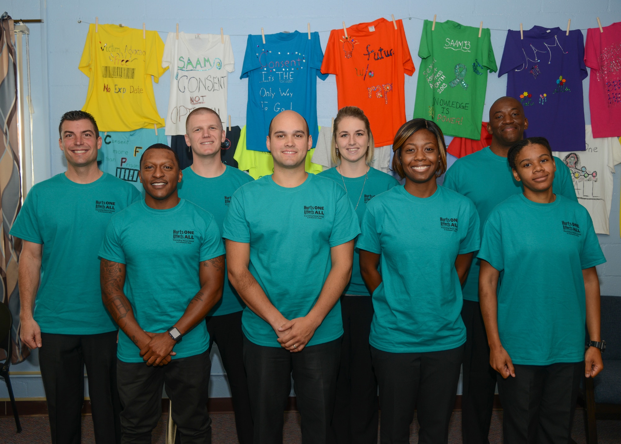 The new Sexual Assault Prevention and Response victim advocates are (back row, left to right) Michael Olson, Kyle Mehlhoff, Tracey Granger, Brandon King (Front Row, left to right) Teslin Turley, Chase Hacault, Arreonnio Jackson and Vernoica Calhoun. The decorated t-shirts in the background were created by various individuals as part of a Support for Survivors campaign. (U.S. Air Force photo by Rebecca Amber)