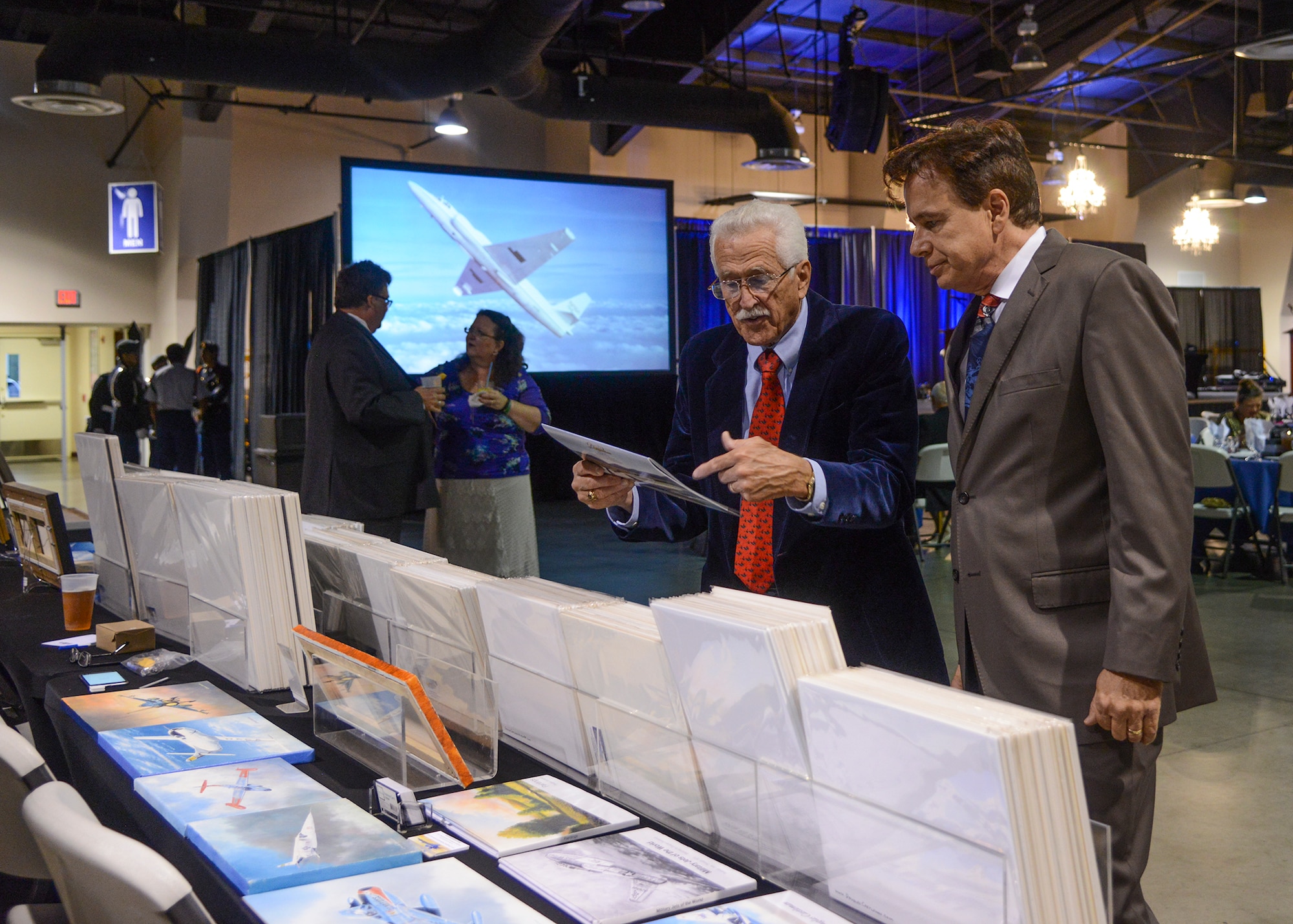 Aviation artist Douglas Castleman (right) talks about the SR-71 with a guest at the 2015 Gathering of Eagles. Castleman and other vendors donated a portion of their proceeds to the Flight Test Historical Foundation to benefit the project to move the Edwards AFB museum outside of the west gate to be more open to the public. (U.S. Air Force photo by Rebecca Amber)