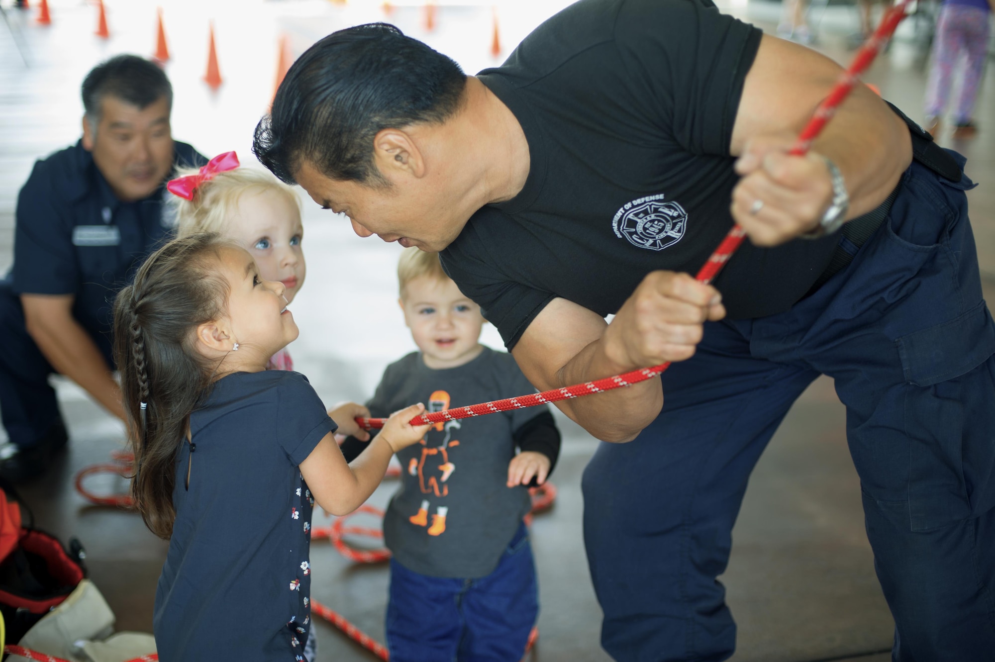 Yokota firefighters help children as they hoist up a dummy during the Yokota fire emergency services 70th anniversary celebration at Yokota Air Base, Japan, Oct. 24, 2015. During the celebration, the 374th CES fire department gave the Yokota community an opportunity to enjoy food, games and simulated firefighting techniques. (U.S. Air Force photo by Airman 1st Class Delano Scott/Released)   