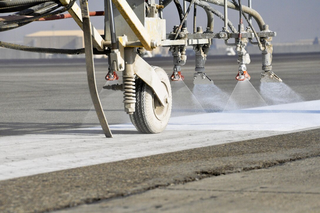 U.S. airmen paint runway markings on Bagram Airfield, Afghanistan, Oct. 22, 2015. The airmen are assigned to the 455th Expeditionary Civil Engineer Squadron. The paint is mixed with reflective beads to ensure the markings can be seen by the pilots coming and going from Bagram in support of Operation Freedom’s Sentinel and NATO’s Resolute Support mission. U.S. Air Force photo by Tech. Sgt. Nicholas Rau