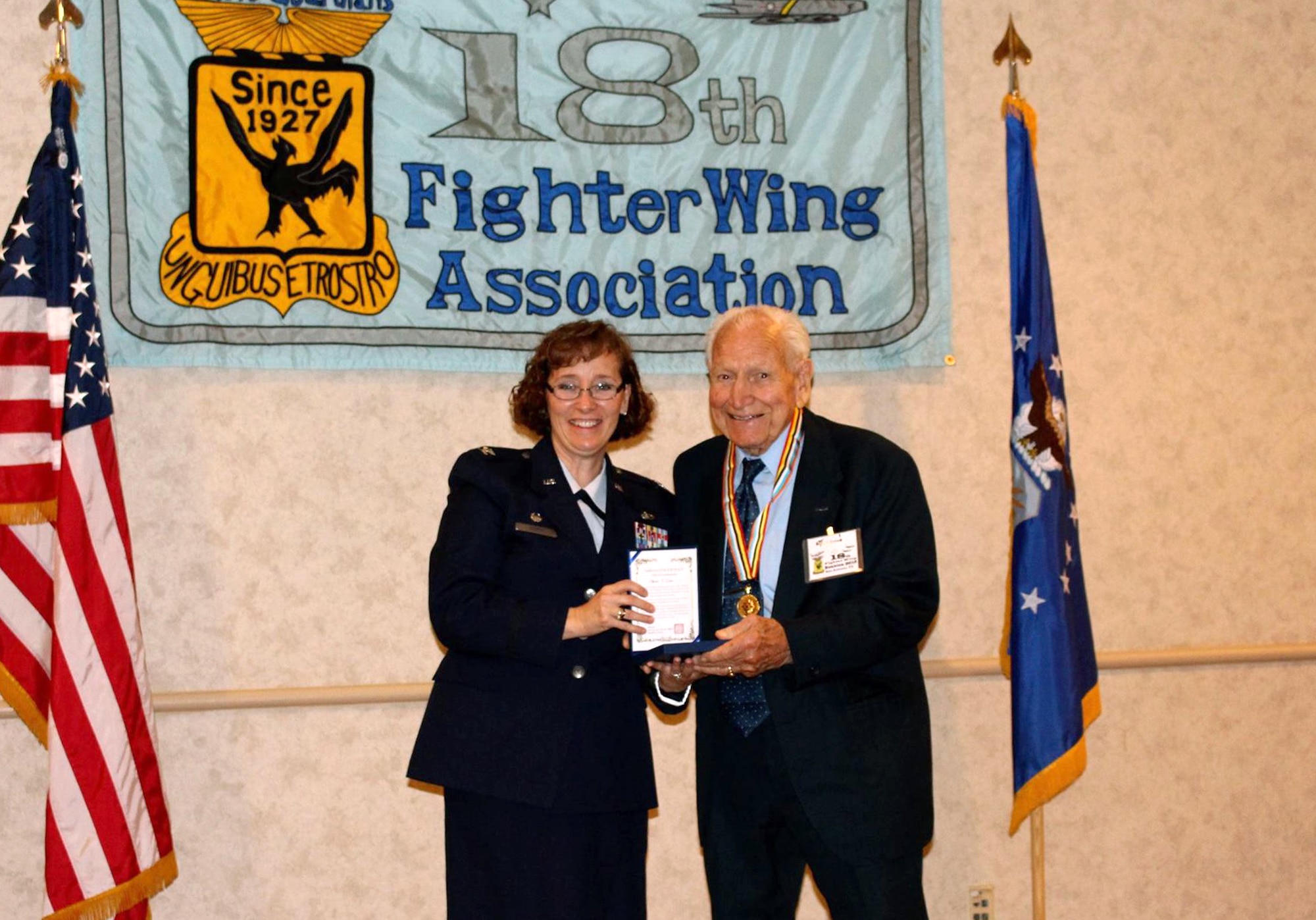 Col. Lisa Craig, 433rd Mission Support Group commander, presents Col. (ret) Julian Crowe with the Republic of Korea Ambassador for Peace Medal Oct. 24 during the 18th Fighter Bomber Wing Association dinner at the Double Tree Hotel San Antonio, Texas. Col. Crow was the commander of the 67th Fighter Bomber Squadron and flew 101 missions in Korea and served twenty-five years in the United States Air Force. (Photo by Susan Kee) (released)